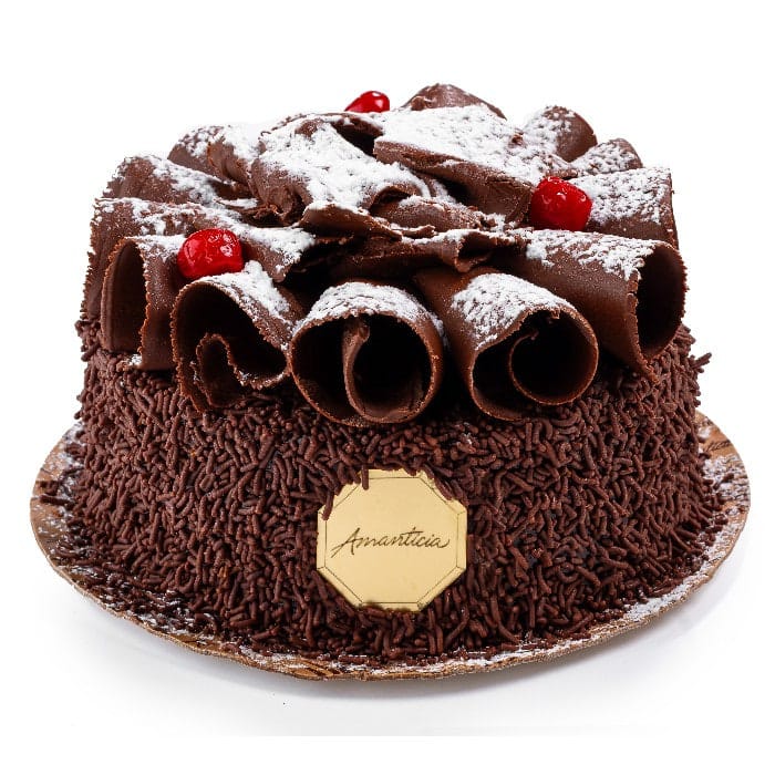 Bolo Floresta Negra coberto com rolos de chocolate, açúcar e cereja